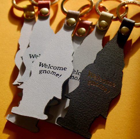 A whimsical leather key accessory embossed with "Welcome Gnome" in reverse, perfect for housewarming or holiday gifts.