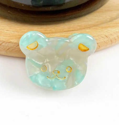 A green bear head-shaped mini hair clip, showcasing its adorable and fun design.