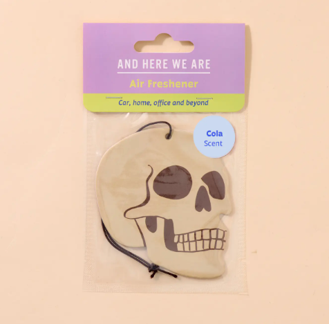 The Skull Air Freshener by And Here We Are in its retail packaging.
