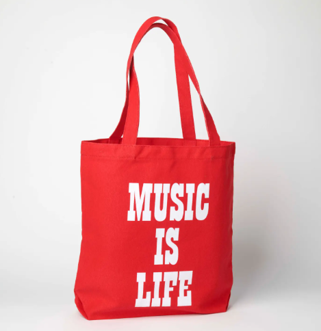 The reverse side of the red canvas tote bag, featuring the bold white text "MUSIC IS LIFE" in a classic typeface.