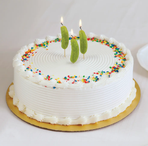 Celebrate with humor using the Pickle Party Candles by Fred & Friends, shown here lit and standing proudly on a frosted birthday cake decorated with colorful sprinkles.