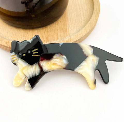 A black and white patterned cat-shaped hair accessory by TheDivaSoap, showcasing a smooth and polished finish.