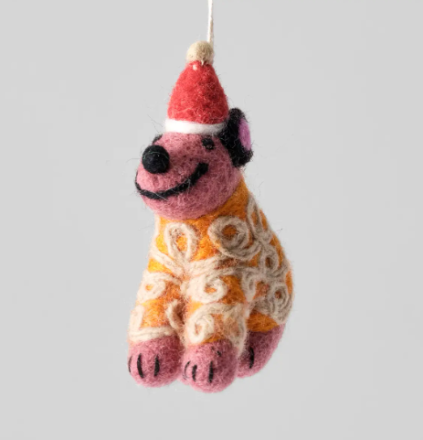 A pink felted wool dog ornament wearing a red Santa hat and an orange jumper with white swirl patterns.