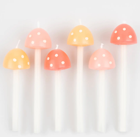 ix 3D mushroom birthday candles in varying heights and pastel shades, lined up to showcase their whimsical polka-dot design.