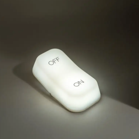 The wireless bedside lamp is shown lit, demonstrating the warm light it provides for a bedside table or bedroom.