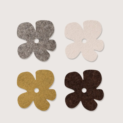 Add a touch of organic charm to your tabletop with the Merino Wool Fleurcoaster 4 Pack by Graf Lantz, featuring four flower-shaped coasters in earthy tones.