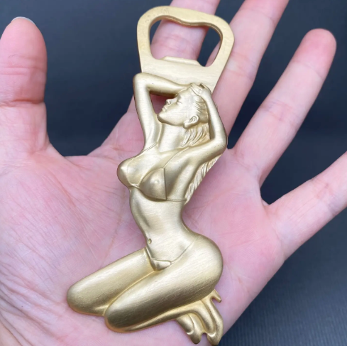 Showcase the compact size of the Mio Queena Brass Bikini Beauty Bottle Opener resting in an open palm.