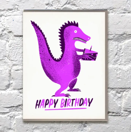 A whimsical A2 greeting card with a dinosaur theme, hand-printed in a small US-based studio using an antique press.