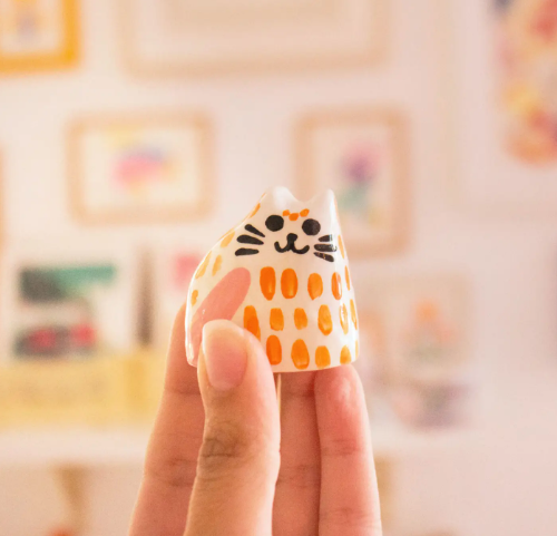 A close-up of the Ana Seixas Baby Cat, showcasing its glossy finish, intricate hand-painted details, and whimsical design.