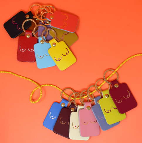 A selection of empowering leather boob keyrings in a variety of vibrant colors, perfect for a bold and meaningful gift.