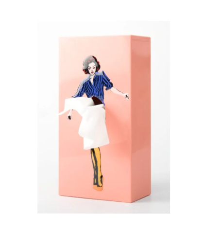 A pink Flying Skirt Tissue Box featuring a pop art illustration of a woman whose skirt is formed by a pulled tissue.
