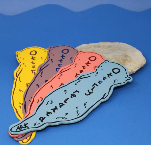The bookmark features a double-sided design, clearly showing the "Otterly Relaxed" embossing, ensuring that the charming otter illustration is visible from any angle.