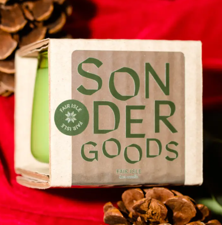 The Fair Isle winter candle by Sonder Goods, hand-poured in a festive green glass vessel with pine and cedarwood notes.