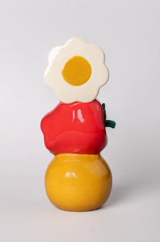 The Ban.do Ceramic Vase, Fun, shown from a back view, highlighting its unique stacked design with a daisy, apple, and smiley face.