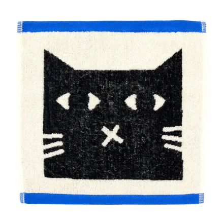 A square cotton face cloth showcasing a bold, charming black cat face illustration with white detailing on an off-white background.