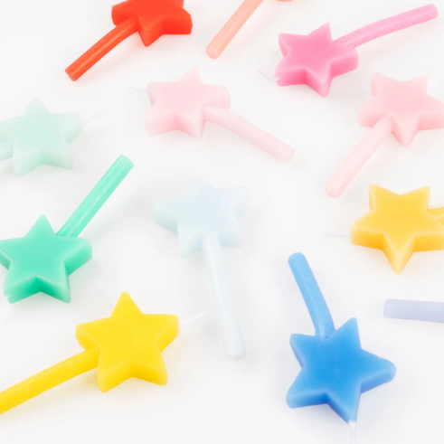A playful scattering of colorful star candles in shades of pink, yellow, blue, and green, ready to add magic to your next party cake.