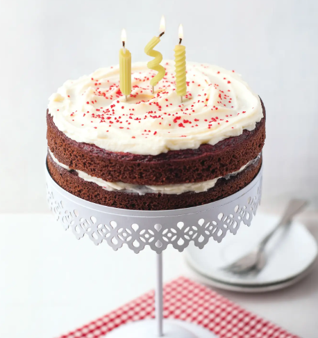 Celebrate with a clever twist using the Pasta Party Noodle Candles by Fred & Friends, shown here lit and standing on a frosted chocolate layer cake.