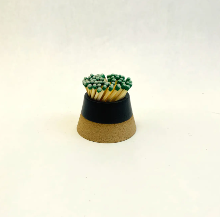 A sleek black ceramic volcano match striker showing the textured exterior perfect for striking matches.