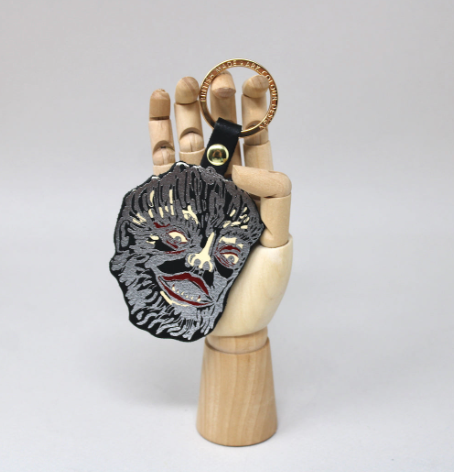 Highlight the intricate hot foil craftsmanship of the Ark Colour Design Leather Werewolf Key Ring held by a wooden decorative hand.