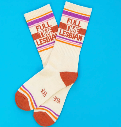 Coordinate your sneakers with American-made statement socks displaying contrast orange heel and toe caps, a wide ribbed top, and bold orange text graphics.