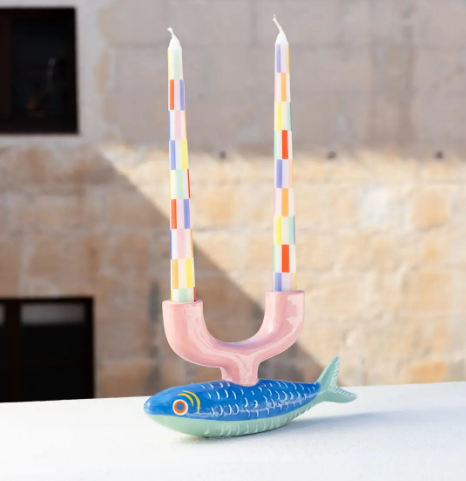 Two-armed fish-shaped taper candle holder in vibrant spring colors, ideal for adding double the ambience to a dinner table.