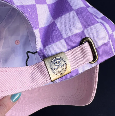The perfect fit! The adjustable band and embossed clasp on the back of the Black Cat Checkerboard Cap by Wokeface.