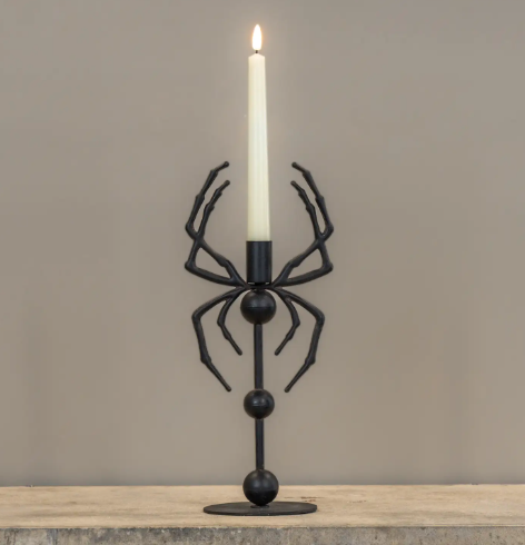 Cast a spell on your seasonal decor with the 13.25-inch Spider Taper Candle Holder by Ragon House, featuring an eerie metal spider design cradling a glowing white candle.