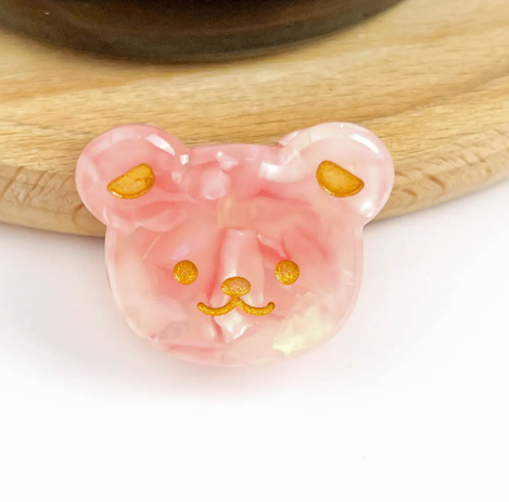 A pink bear head-shaped mini hair clip, showcasing its adorable and fun design.