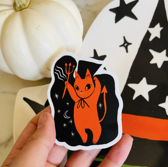 Get into the spooky spirit with the irresistibly cute Demonio Cat waterproof vinyl sticker by Bunny Dee, perfect for jazzing up your Halloween gear.