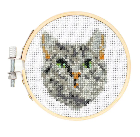 A finished example of the cat embroidery design, displayed neatly within the round bamboo hoop.