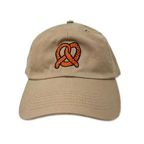 A beige cotton chino hat with an embroidered orange pretzel design on the front.