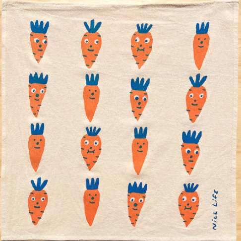 A classic and charming hand-printed cotton tea towel with a colorful carrot design, ideal for a rustic or modern kitchen.