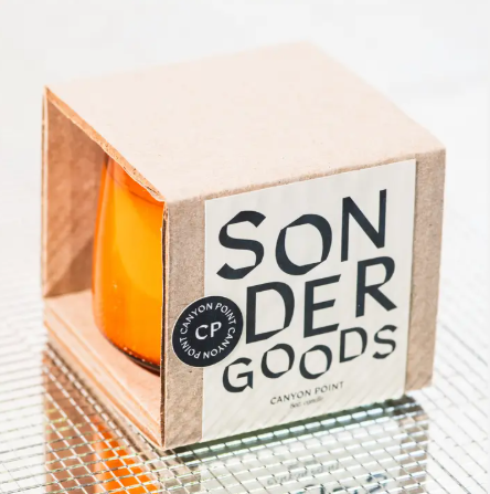 A minimalist Sonder Goods soy candle in an amber glass jar, featuring a destination-inspired scent like Canyon Point.