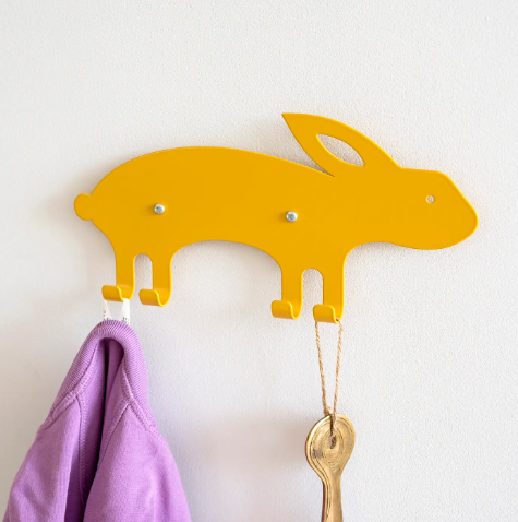 A cheerful yellow rabbit-shaped wall hook made of steel, showcasing its playful design and bent legs that serve as a functional hook.