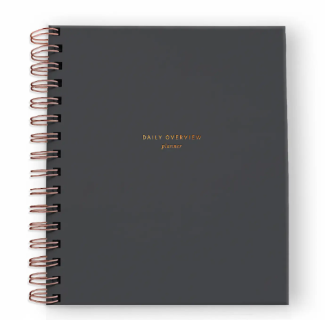 A minimalist charcoal daily planner with elegant gold foil detailing, promoting intentional living and mindful planning.