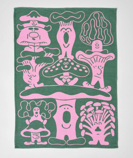 A rectangular woven cotton dish towel from Wrap, with a cheerful mushroom-themed design in contrasting pink and green hues.