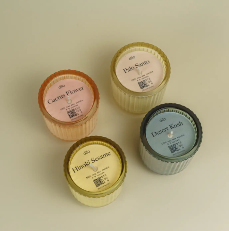 A curated set of four dilo candles in clear ribbed glass jars with minimalist white labels and black text.