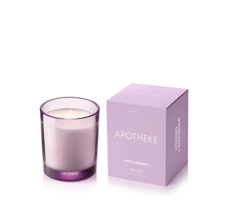 A petite Hinoki Lavender candle by Apotheke in a translucent lavender purple glass jar next to a matching purple box.
