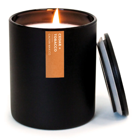 The exquisite Cedar + Tobacco matte black candle, offering a distinguished fragrance and supporting a powerful cause.