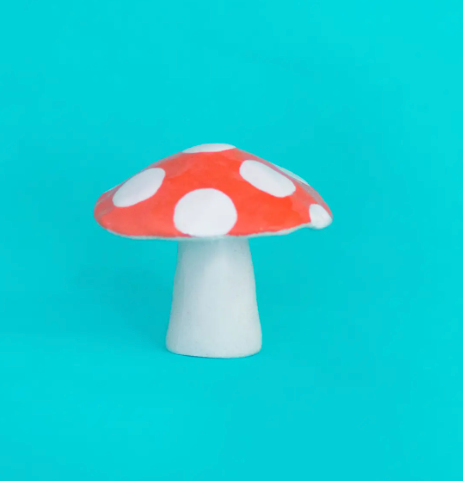 A back view of the Ana Seixas Mini Mushroom, showcasing its glossy red cap, light brown textured stem, and handcrafted details, emphasizing its unique, sculptural form.