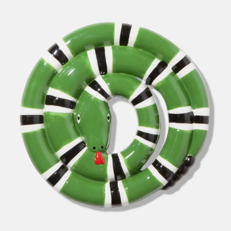 Keep your dining table safe from hot cookware with an eccentric green ceramic trivet showcasing a striped snake detailed with a bright red forked tongue.