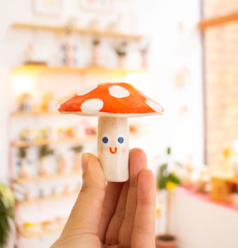 The Ana Seixas Mini Mushroom, highlighting its small size and how it can charmingly accent indoor plants or natural decor settings.