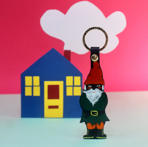 A Black handcrafted leather key fob in the shape of a cheeky gnome with red and blue foil detailing.