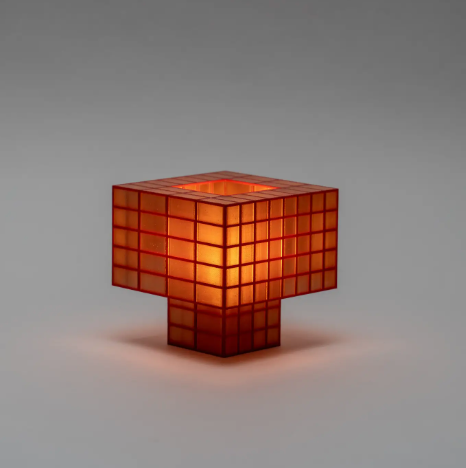 View the rich amber hue of the Tesser 5-3 Lamp by Ridezign, casting a cozy and inviting light from a tabletop surface.