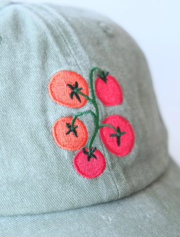 A close-up shot of the embroidery on the tomato vine hat, highlighting the intricate details of the design.