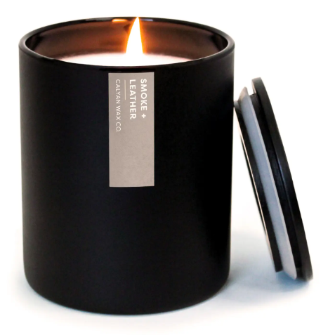 The sleek Smoke + Leather candle with a modern matte black tumbler and matching wooden lid, a sophisticated accessory for any space.