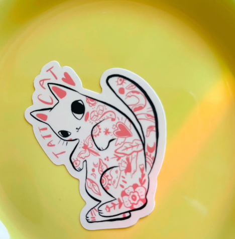Showcase your edgy, ink-inspired style with the charming Tatt Cat matte vinyl sticker by Bunny Dee.