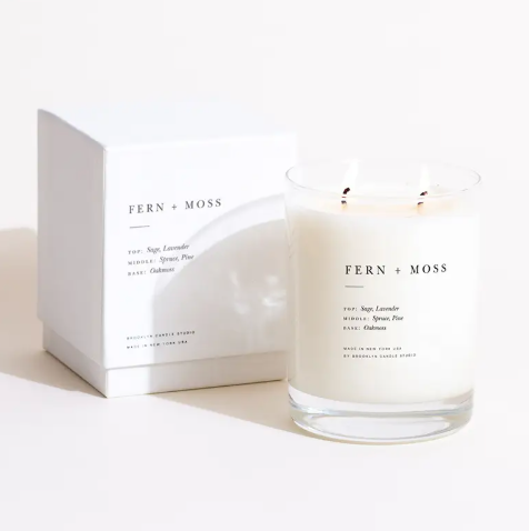 The elegant Brooklyn Candle Studio Fern + Moss 2-Wick Candle in its clear glass tumbler and minimalist box, inspired by a Northern California forest.
