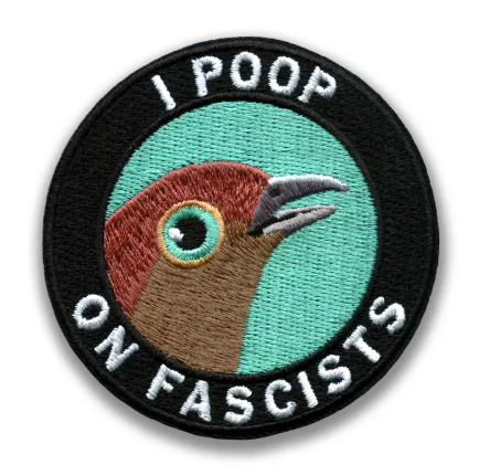 The 'I Poop On Fascists' embroidered patch by The Mincing Mockingbird, a circular design featuring a bird with a side-eye against a teal and black background.