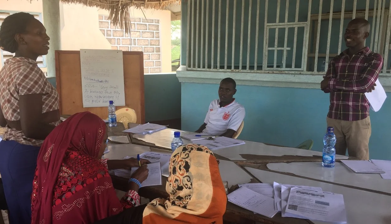 Philip Amara (right) interacts with participants during a workshop to train budding entrepreneurs in Tana River County